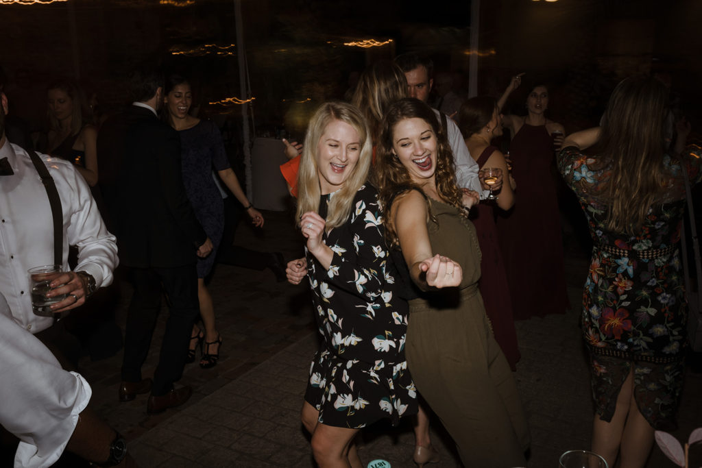 two ladies ripping it up on the dancefloor during a wedding reception celebration