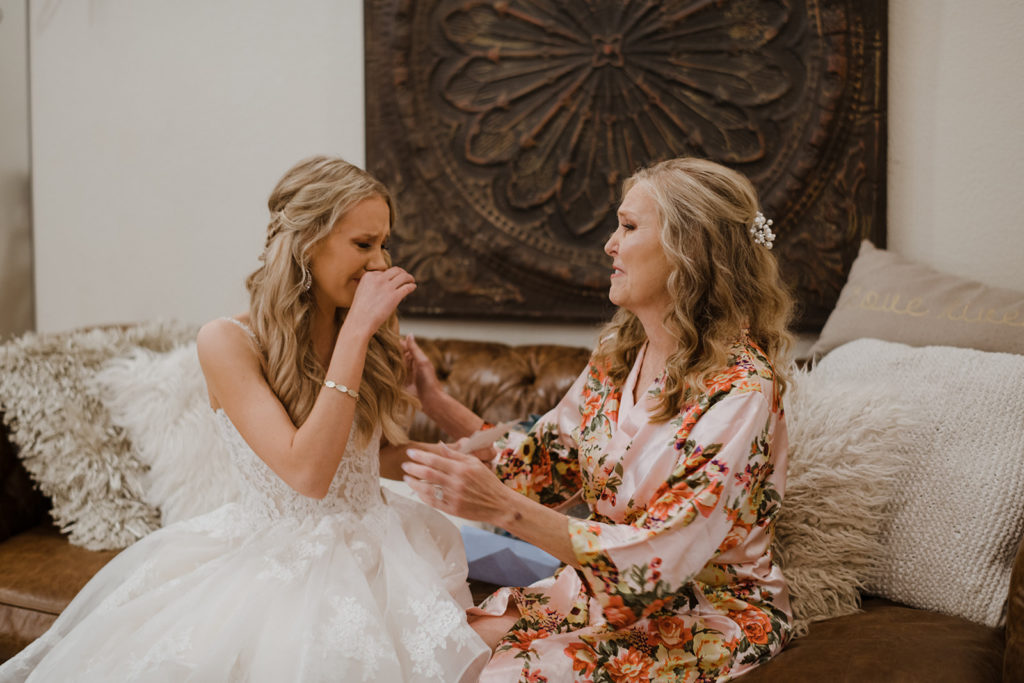 blonde bride and her beautiful mom share a moment of love and tears before the ceremony. Importance of preserving digital memories.
